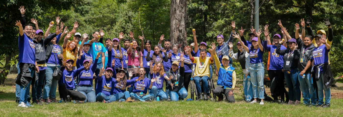 Grupo de voluntarios Teletón celebrando al aire libre con las manos levantadas