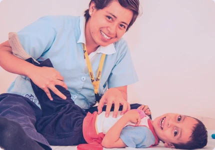 Voluntaria Teletón acompañando a un paciente en terapia