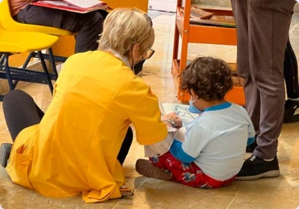 Voluntaria Teletón jugando con un niño en el CRIT