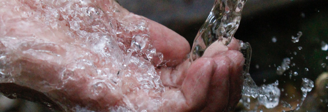 Fotografía de una mano atrapando un chorro de agua. Foto por Samad Deldar para Pexels