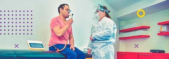 Fotografía de especialista en rehabilitación pulmonar dando terapia a un paciente en un Centro Teletón
